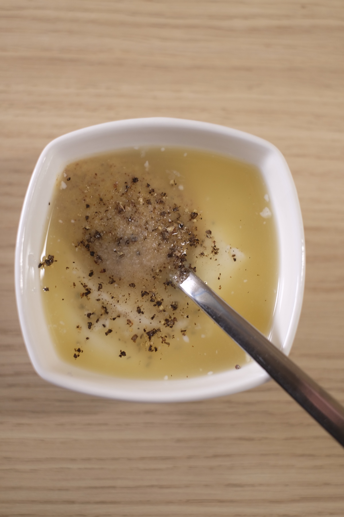 Greek yogurt, mustard, lemon juice and pepper before mixing dressing for avocado egg salad