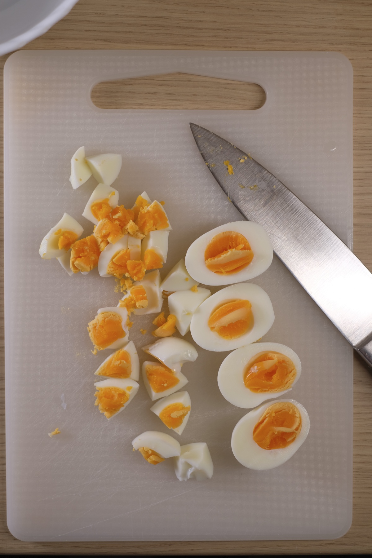 Chopped boiled eggs on a cutting board for avocado egg salad