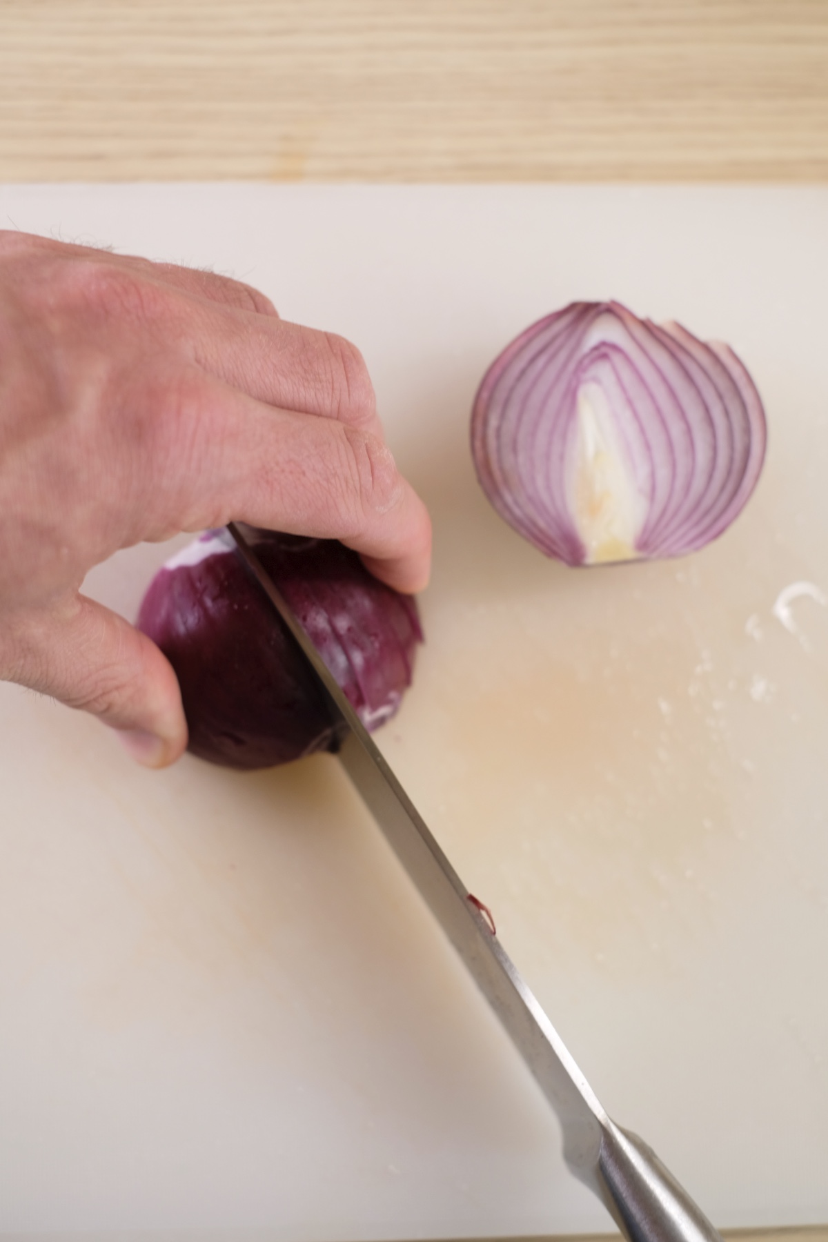I cut red onion in half to prepare it for spicy egg salad