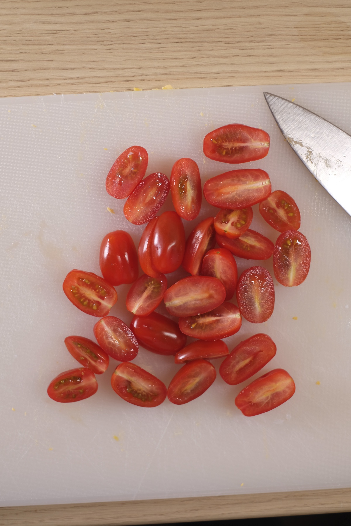 Halved cherry tomatoes prepared for avocado egg salad