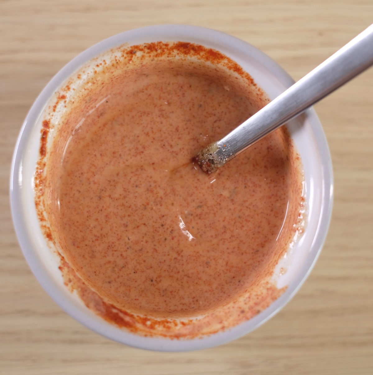 Greek yogurt dressing with sriracha, mustard, lime juice and spices after mixing