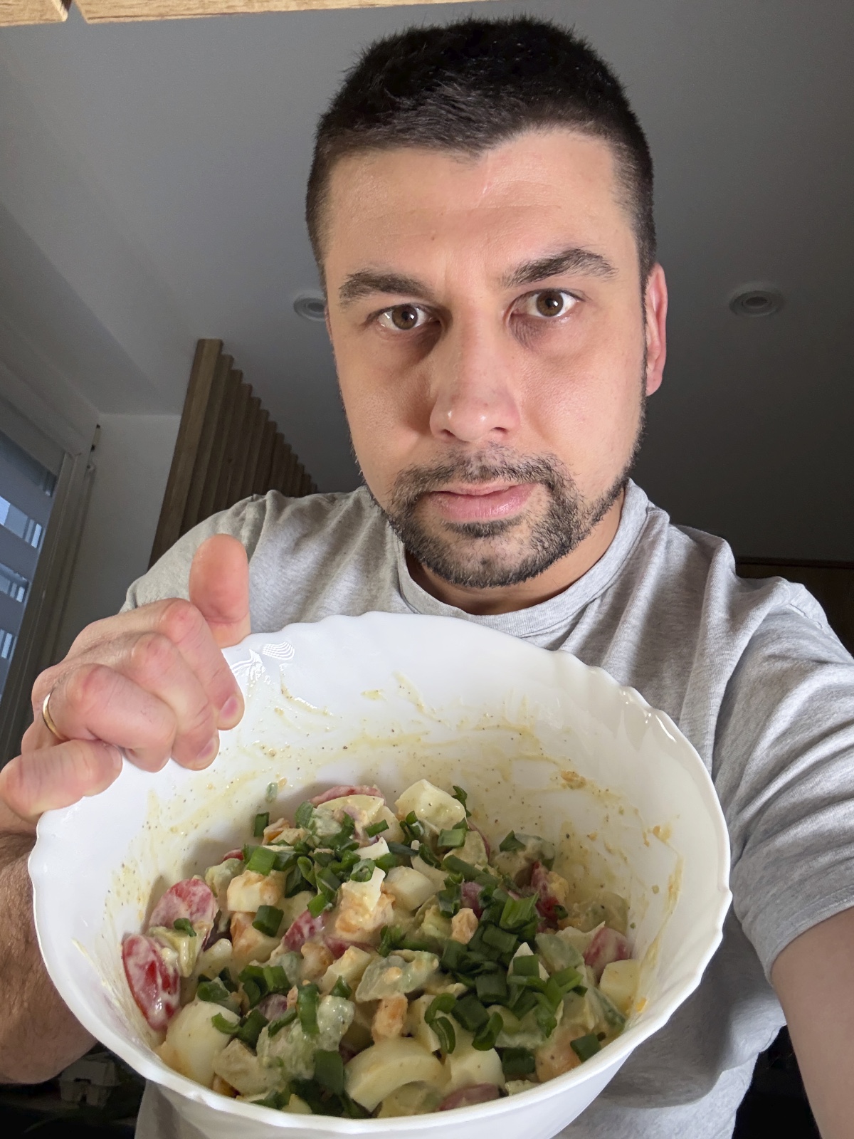 Man eating homemade avocado egg salad with cherry tomatoes and chives