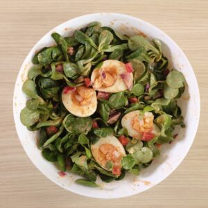 Spicy egg salad with lamb's lettuce, eggs and vegetables mixed together with creamy dressing