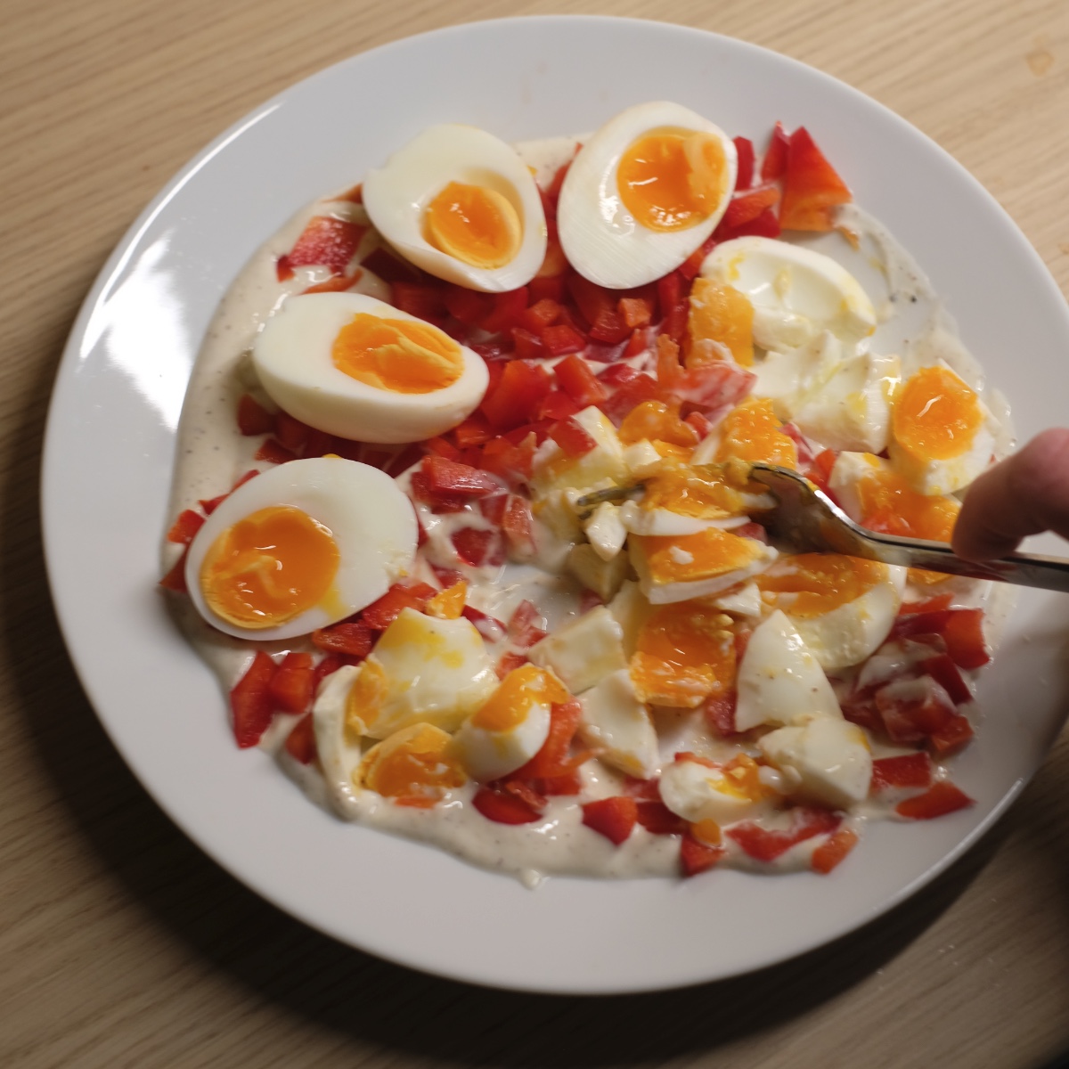 mixing egg salad with yogurt and red pepper